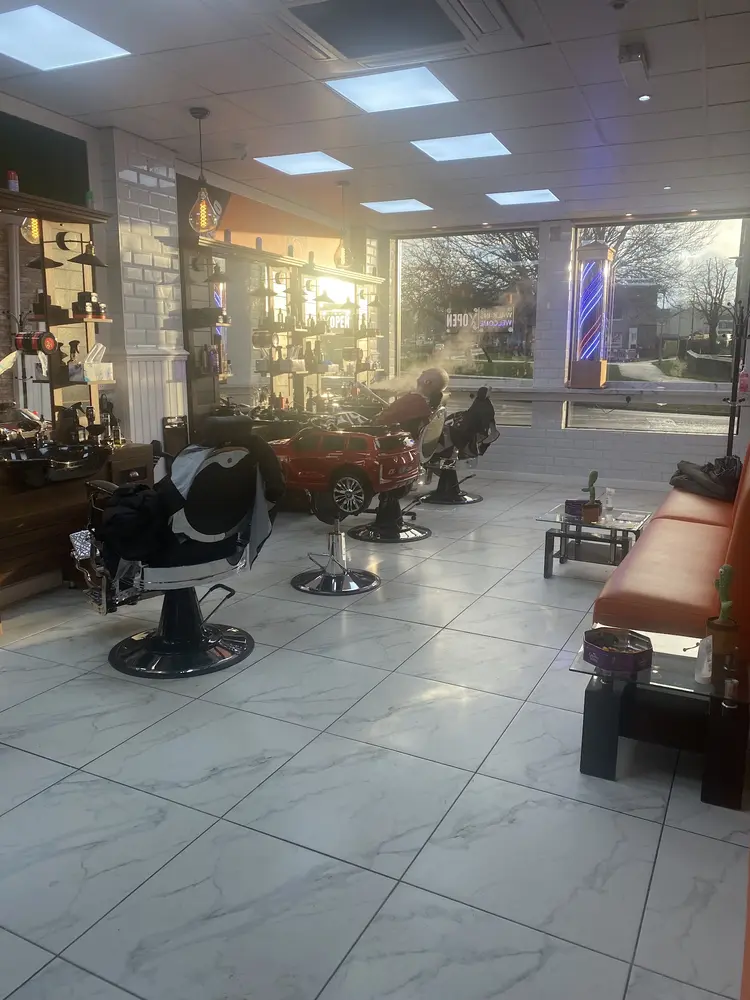 Inside Turkish Style barbershop with barber chairs, a red toy car and an orange bench
